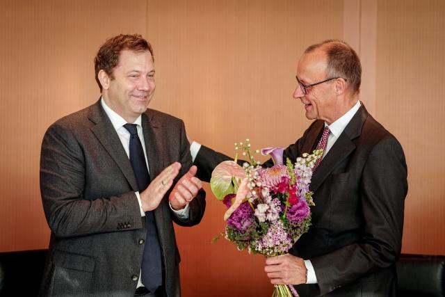 12 November 2025, Berlin: German Chancellor Friedrich Merz accepts the applause and flowers from Lars Klingbeil, German Minister of Finance, Vice Chancellor and SPD Federal Chairman, on the occasion of his 70th birthday on November 11, 2025 at the beginning of the Federal Cabinet meeting in the Federal Chancellery. Photo: Kay Nietfeld/dpa