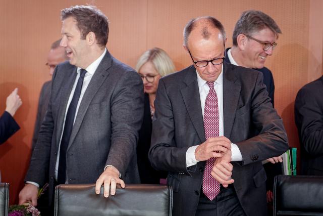 12 November 2025, Berlin: German Chancellor Friedrich Merz looks at his watch at the start of the Federal Cabinet meeting in the Federal Chancellery alongside Lars Klingbeil, Federal Minister of Finance, Vice-Chancellor and SPD Federal Chairman, and Wolfgang Weimer, Minister of State for Culture. Photo: Kay Nietfeld/dpa