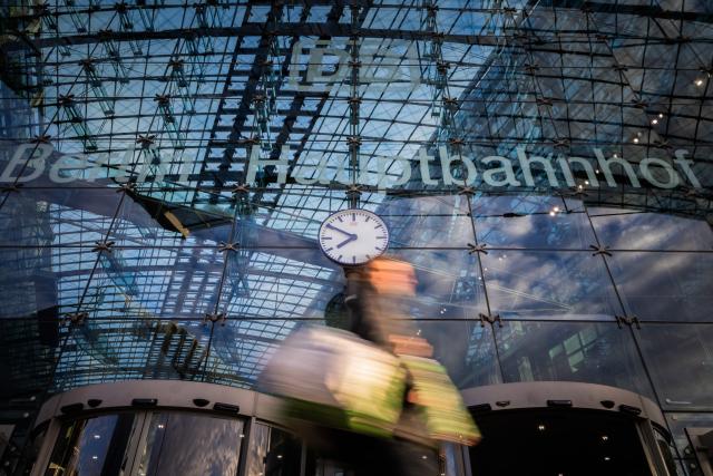 FILED - 30 March 2025, Berlin: A passer-by walks past the clock at Berlin Central Station. Photo: Christoph Soeder/dpa
