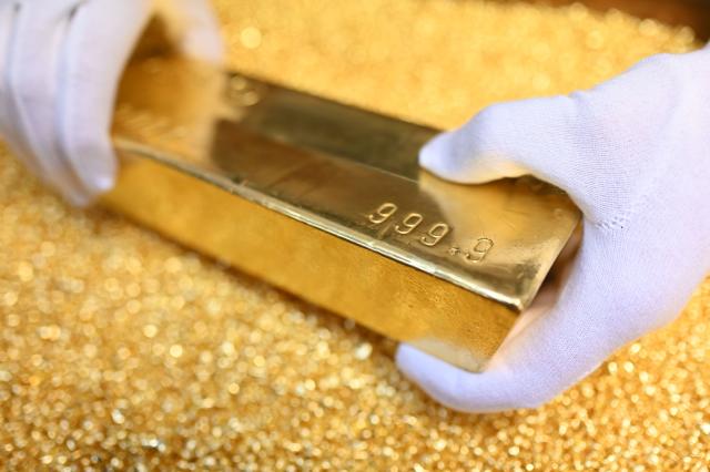 FILED - 20 March 2023, Pforzheim: A gold bar weighing 12.5 kilograms is placed on gold granules at Agosi AG in Pforzheim. Photo: Uli Deck/dpa