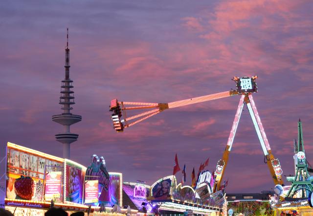 12 November 2025, Hamburg: The gondolas of a ride can be seen in front of Hamburg's Heinrich-Hertz-Turm television tower at the Hamburg Winter Dome on Heiligengeistfeld. The Winter Dome takes place from November 7 to December 7. Photo: Marcus Brandt/dpa