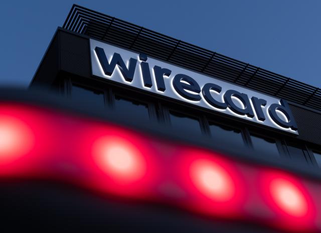 FILED - 20 July 2020, Bavaria, Aschheim: Red lights shine in front of the Wirecard logo at the former headquarters of the payment service provider. Photo: Peter Kneffel/dpa