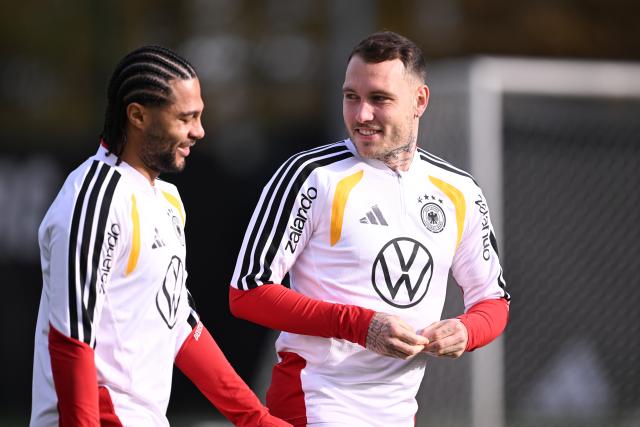 13 November 2025, Lower Saxony, Wolfsburg: Germany's Serge Gnabry (L) and David Raum chat during a training session ahead of Friday's FIFA World Cup qualifier soccer match against Luxembourg. Photo: David Inderlied/dpa
