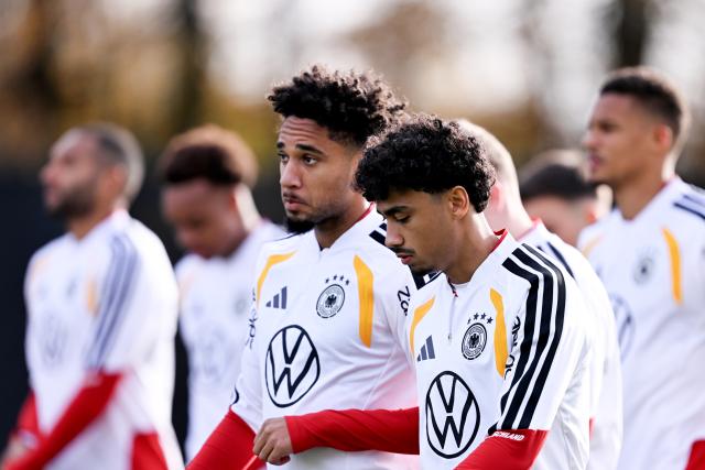 13 November 2025, Lower Saxony, Wolfsburg: Germany's (L-R) Kevin Schade and Nathaniel Brown interact during a training session ahead of Friday's FIFA World Cup qualifier soccer match against Luxembourg. Photo: David Inderlied/dpa