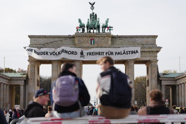 13 November 2025, Berlin: Pro-Palestine activists hang a banner climbed onto the Brandenburg Gate in Berlin. Photo: Kay Nietfeld/dpa