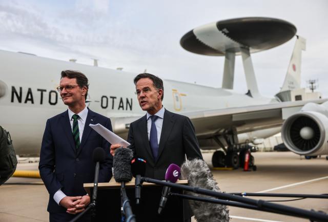 13 November 2025, North Rhine-Westphalia, Geilenkirchen: Hendrik Wuest (L), Minister President of North Rhine-Westphalia and Mark Rutte (R), NATO Secretary General give a press statement in front of an AWACS aircraft during a visit the NATO Airborne Early Warning and Control Force in Geilenkirchen. Photo: Oliver Berg/dpa