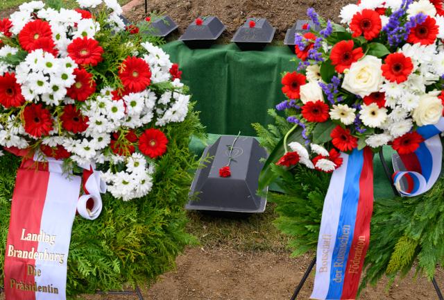 14 November 2025, Brandenburg, Lebus: A wreath from the Brandenburg state parliament and a wreath with the national colors of Russia can be seen at a burial of Soviet soldiers who died in the Second World War at the Soviet war cemetery. The German War Graves Commission in Brandenburg is fulfilling its humanitarian mission with the silent burial of 39 Soviet soldiers, which recovered from various locations in Brandenburg in recent years. Photo: Patrick Pleul/dpa