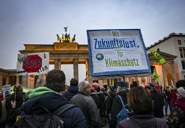 14 November 2025, Berlin: Demonstrators from the Fridays for Future climate movement stand at the Brandenburg Gate on the occasion of the COP30 world climate conference. Photo: Jens Kalaene/dpa