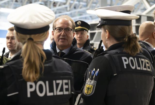 14 November 2025, Bavaria, Munich: German Minister of the Interior Alexander Dobrindt (C) finds out about the Federal Police's priority operation at Munich Central Station. To combat violent crime, the Federal Police will be carrying out priority operations at various train stations in Germany from November 14 to 16. Photo: Peter Kneffel/dpa