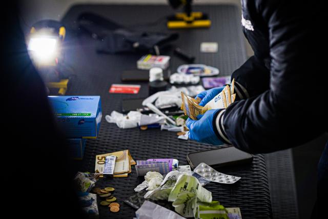 14 November 2025, Lower Saxony, Hanover: A plainclothes police officer from the Federal Police counts cash at Hanover Central Station, which was previously found during a check on a young man. The measures are part of a nationwide focus on stations with a high level of violence. Photo: Moritz Frankenberg/dpa