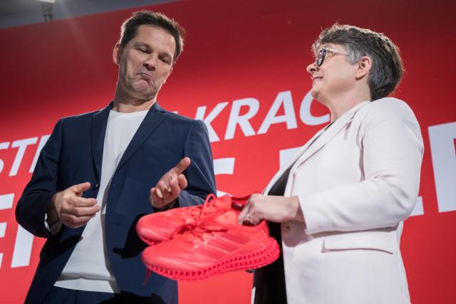 15 November 2025, Berlin: Steffen Krach, the SPD's lead candidate for the 2026 election to the Berlin House of Representatives, looks at red running shoes presented to him by Nicola Böcker-Giannini (SPD), Chairwoman of the SPD Berlin, after his nomination at the SPD Berlin state party conference. The top candidate for the election to the Berlin House of Representatives on September 20, 2026 is to be chosen at the party conference. Photo: Sebastian Christoph Gollnow/dpa