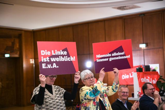 15 November 2025, Saxony-Anhalt, Leuna: Signs with slogans are raised after the vote on the main motion at the 10th state party conference of the Left Party of Saxony-Anhalt at the cCe Kulturhaus in Leuna. Photo: Heiko Rebsch/dpa