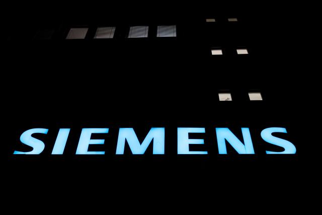 FILED - 16 November 2017, Berlin: A general view of a lit logo on the facade of the Siemens factory. Photo: Ralf Hirschberger/dpa-Zentralbild/dpa
