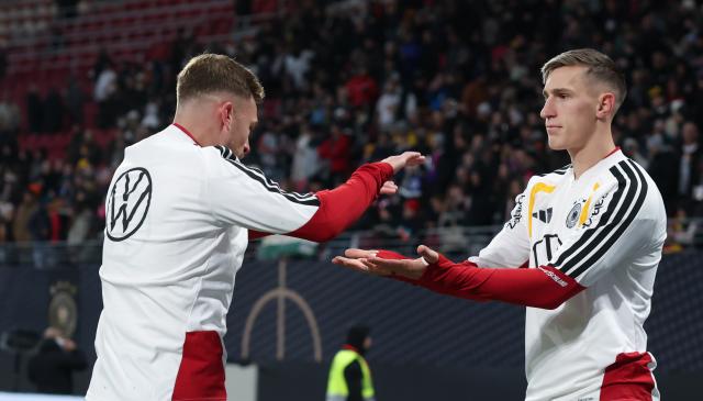 17 November 2025, Saxony, Leipzig: Germany's Joshua Kimmich (L) and Nico Schlotterbeck react on the pitch ahead of the FIFA World Cup European qualifying soccer match between Germany and Slovakia at Red Bull Arena. Photo: Jan Woitas/dpa