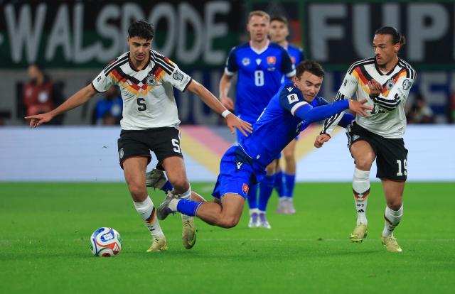 17 November 2025, Saxony, Leipzig: Germany's Aleksandar Pavlovic (L) and Germany's Leroy Sane (R) and Slovakia's David Strelec battle for the ball during the FIFA World Cup European qualifying match between Germany and Slovakia at Red Bull Arena. Photo: Jan Woitas/dpa