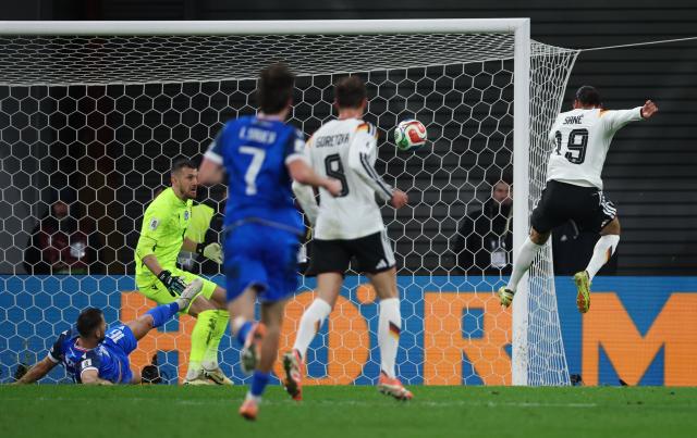 17 November 2025, Saxony, Leipzig: Germany's Leroy Sane (R) beats Slovakia goalkeeper Martin Debravka (2nd L) to score his side's fourth goal during the FIFA World Cup European qualifying soccer match between Germany and Slovakia at Red Bull Arena. Photo: Jan Woitas/dpa