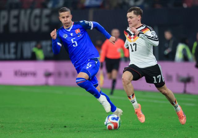 17 November 2025, Saxony, Leipzig: Germany's Florian Wirtz (R) and Slovakia's Lubomir Satka battle for the ball during the FIFA World Cup European qualifying match between Germany and Slovakia at Red Bull Arena. Photo: Jan Woitas/dpa