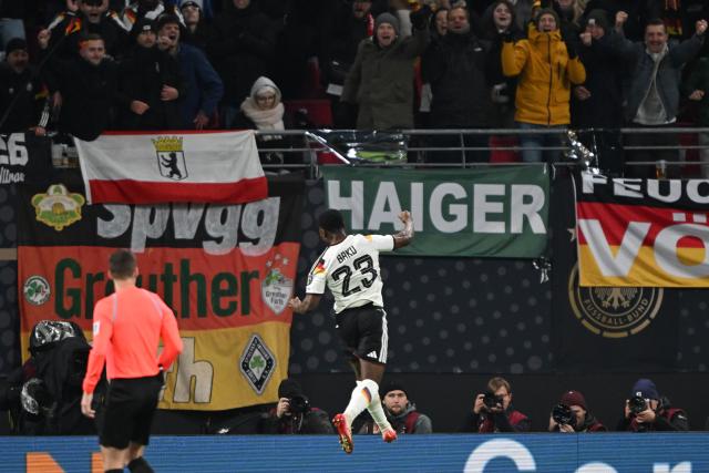 17 November 2025, Saxony, Leipzig: Germany's Ridle Baku (L) celebrates after scoring his side fifth goal of the game during the FIFA World Cup European qualifying match between Germany and Slovakia at Red Bull Arena. Photo: Robert Michael/dpa