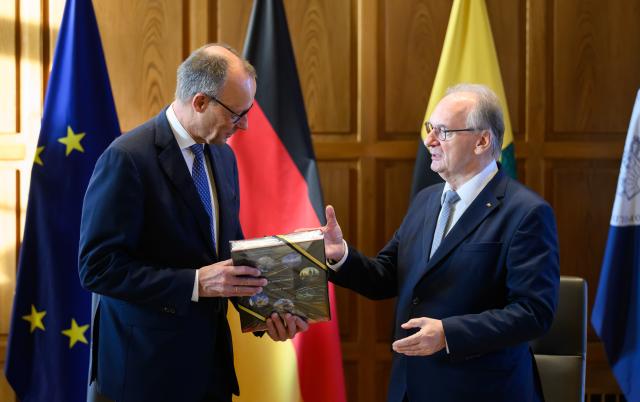 18 November 2025, Saxony-Anhalt, Halle: German Chancellor Friedrich Merz (L) meets with Minister President of Saxony-Anhalt Reiner Haseloff during his inaugural visit to the National Academy of Sciences Leopoldina. Photo: Robert Michael/dpa