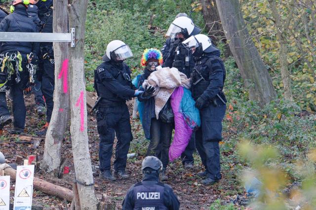 18 November 2025, North Rhine-Westphalia, Kerpen: Police officers escort activists out of the so-called "Suendenwaeldchen" on the edge of the Hambach open-cast mine in Hambach Forest. The police have begun a large-scale operation to clear a last piece of forest occupied by activists at the Hambach open-cast lignite mine in the Rhenish mining area. Photo: Henning Kaiser/dpa