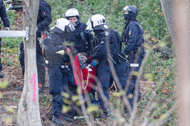 18 November 2025, North Rhine-Westphalia, Kerpen: Police officers carry an activist out of the so-called "Suendenwaeldchen" on the edge of the Hambach open-cast mine in Hambach Forest. The police have begun a large-scale operation to clear a last piece of forest occupied by activists at the Hambach open-cast lignite mine in the Rhenish mining area. Photo: Henning Kaiser/dpa