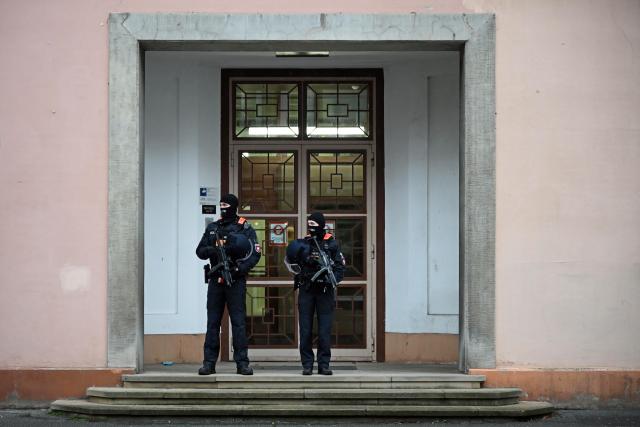 18 November 2025, Lower Saxony, Celle: Two police officers stand in front of the Higher Regional Court before the start of a trial against a suspected member of Hezbollah. Photo: Shireen Broszies/dpa