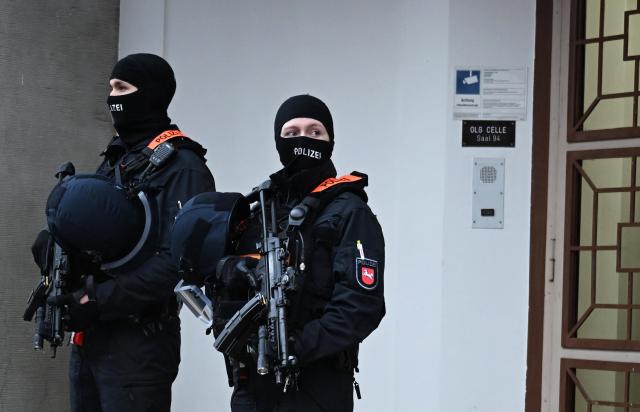 18 November 2025, Lower Saxony, Celle: Two police officers stand in front of the Higher Regional Court before the start of a trial against a suspected member of Hezbollah. Photo: Shireen Broszies/dpa