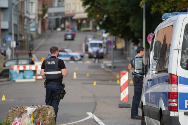 FILED - 22 August 2025, Saarland, Voelklingen: Police officers investigate the area around a crime scene. A police officer has been killed by gunfire after a robbery at a petrol station in Voelklingen. Photo: Patrick von Frankenberg/dpa