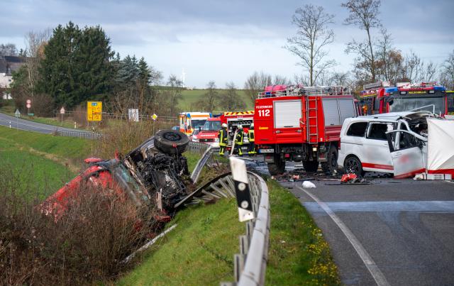 18 November 2025, Rheinland-Pfalz, Welschbillig-Windmuehle: A truck lies behind the crash barrier on a slope on the B51 near Welschbillig after a head-on collision with a minibus (R). Photo: Harald Tittel/dpa