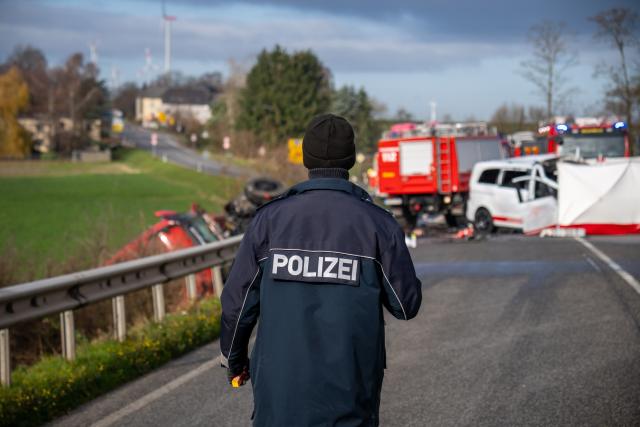 18 November 2025, Rheinland-Pfalz, Welschbillig-Windmuehle: A police officer goes to the scene of an accident on the B51 near Welschbillig, where a minibus collided head-on with a truck this morning. Photo: Harald Tittel/dpa