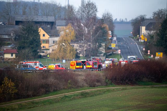 18 November 2025, Rheinland-Pfalz, Welschbillig-Windmuehle: Emergency vehicles are parked on the B51 federal highway, where a truck collided head-on with a minibus this morning. Photo: Harald Tittel/dpa