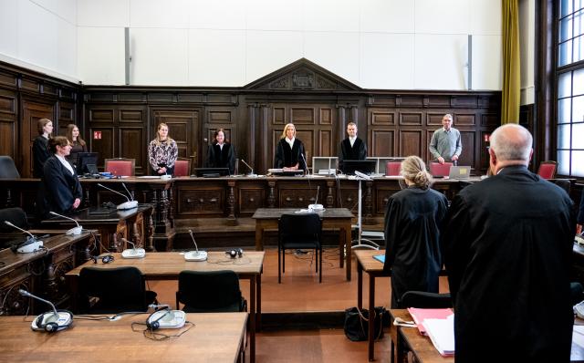 18 November 2025, Hamburg: Presiding judge at the regional court Birgit Woitas (C) stands in the courtroom before the start of the trial of a 39-year-old woman who allegedly stabbed people indiscriminately on a platform at Hamburg Central Station in May 2025 at the district court. Photo: Daniel Bockwoldt/dpa