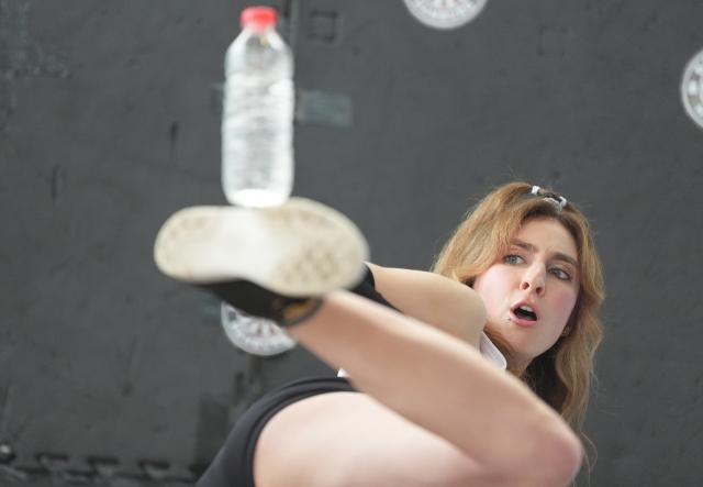 18 November 2025, Hamburg: Palina Glebova kicks a bottle during Guinness World Records Day 2025 at Elbtor Mobile. Glebova has set a new record in the discipline "Most bottles thrown up with the foot and then kicked sideways at least three meters". Photo: Marcus Brandt/dpa