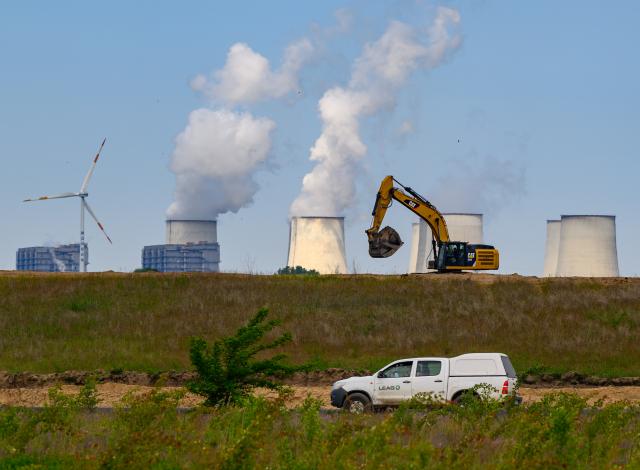 FILED - 21 May 2025, Brandenburg, Jänschwalde: The cooling towers of the Jaenschwalde lignite-fired power plant rise into the sky behind the former Jaenschwalde opencast lignite mine operated by Lausitz Energie Bergbau AG (LEAG). More than 60 church institutions worldwide are ruling out future investments in fossil fuels such as oil, gas and coal, including Germany's Protestant Church. Photo: Patrick Pleul/dpa