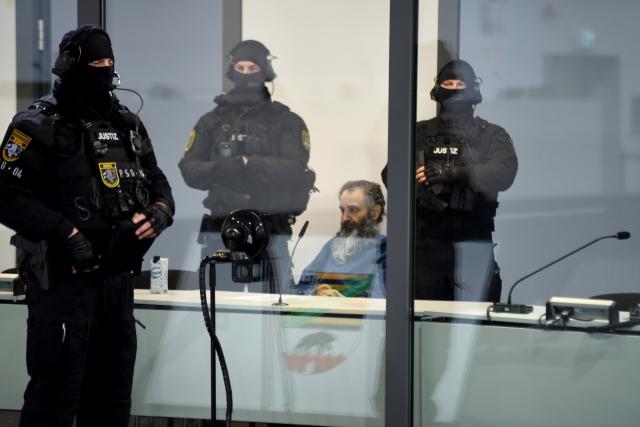 19 November 2025, Saxony-Anhalt, Magdeburg: The defendant Taleb al-Abdulmohsen (C) sits in a bulletproof glass box in the temporary court building at Magdeburg District Court, as the public prosecutor's office is accusing hime with 338 counts of attempted murder. On December 20, 2024, the accused drove through the Magdeburg Christmas market. Six people were killed in the attack: five women aged between 45 and 75 and a nine-year-old boy. Photo: Simon Kremer/dpa