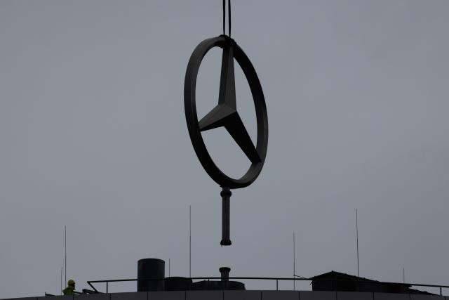 19 November 2025, North Rhine-Westphalia, Cologne: An oversized Mercedes star hangs from a crane truck after being dismantled from the roof of the the Stuttgart-based car manufacturer Mercedes-Benz branch. Photo: Rolf Vennenbernd/dpa