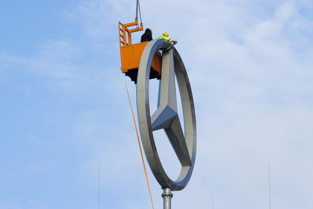 19 November 2025, North Rhine-Westphalia, Cologne: Workers from a crane company prepare to dismantle a Mercedes star on the roof of the the Stuttgart-based car manufacturer Mercedes-Benz branch. Photo: Rolf Vennenbernd/dpa