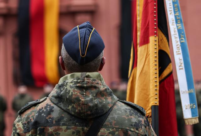 19 November 2025, Rhineland-Palatinate, Mainz: A soldier carries a German flag at the Ceremonial pledge on the 70th anniversary of the founding of the German Armed Forces (Bundeswehr). Around 160 recruits from the air force training battalion from Roth and the Homeland Security Regiment 5 from Hesse, based in Thuringia, took their oath of service. Photo: Hannes P. Albert/dpa