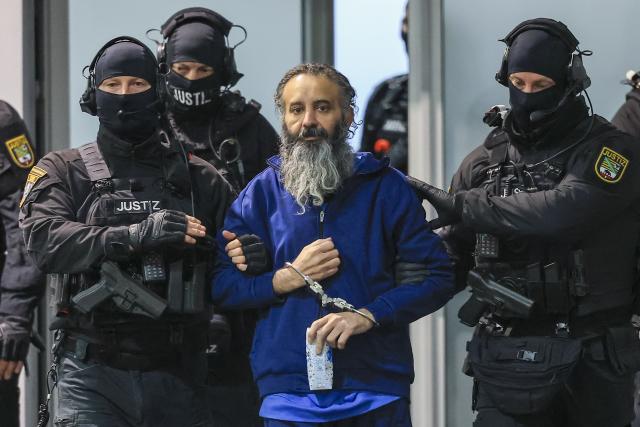 20 November 2025, Saxony-Anhalt, Magdeburg: Judicial officers lead the handcuffed defendant Taleb al-Abdulmohsen into the temporary court building at 
Magdeburg Regional Court. On December 20, 2024, Taleb al-Abdulmohsen drove into a crowd of people at Magdeburg's Christmas market, killing 6 and injuring more than 300 people. Photo: Jan Woitas/dpa