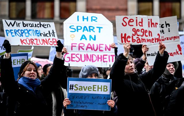20 November 2025, Berlin: Demonstrators stand in front of the Berlin House of Representatives and protest against cuts to midwifery courses and for better working conditions for midwives. Photo: Britta Pedersen/dpa