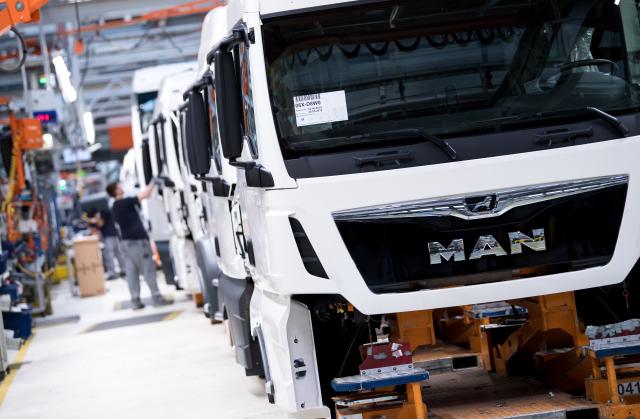 FILED - 16 May 2018, Bavaria, Munich: MAN Truck & Bus employees work in a production line. Photo: Sven Hoppe/dpa
