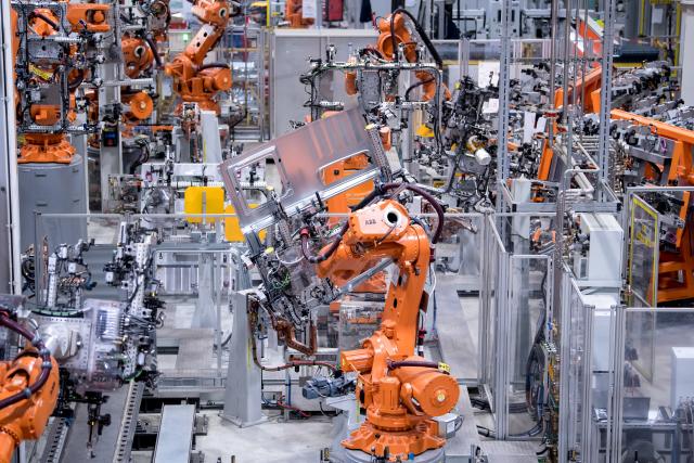 FILED - 16 May 2018, Bavaria, Munich: Robots work on the side walls of truck driver's cabs at MAN Truck & Bus in a factory hall. Photo: Sven Hoppe/dpa