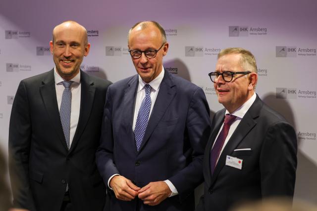 21 November 2025, North Rhine-Westphalia, Arnsberg: (L-R) Joerg Nolte, Managing Director of IHK Arnsberg - Hellweg-Sauerland, German Chancellor Friedrich Merz and Andreas Knappstein, President of IHK Arnsberg - Hellweg-Sauerland, at the annual reception of the IHK Arnsberg, the Chamber of Commerce Arnsberg, Hellweg-Sauerland. Photo: Christoph Reichwein/dpa