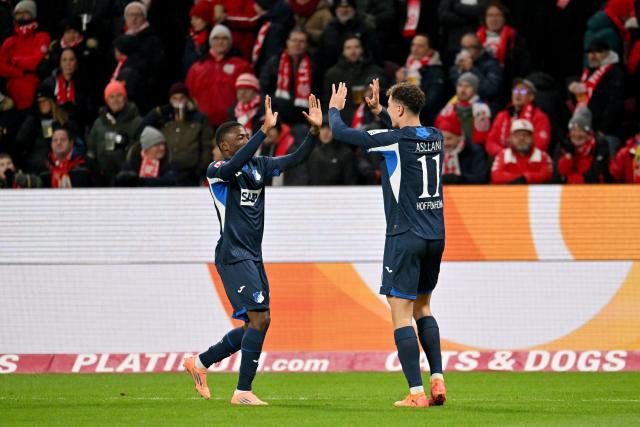 21 November 2025, Rhineland-Palatinate, Mainz: Hoffenheim's Bazoumana Toure and Fisnik Asllani celebrate their first goal, an own goal scored by Mainz' Hanche-Olsen during the German Bundesliga FSV Mainz 05 and TSG 1899 Hoffenheim at the Mewa Arena. Photo: Torsten Silz/dpa