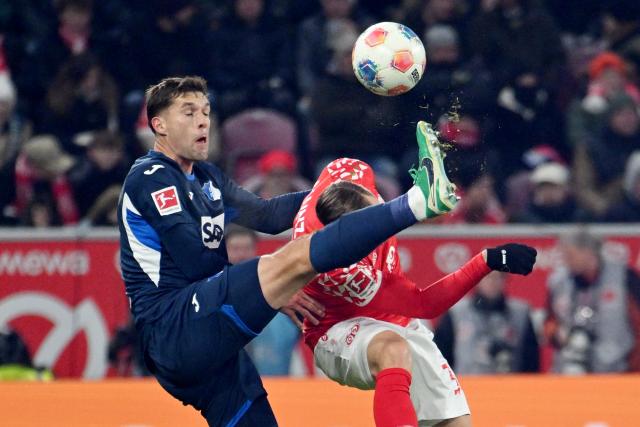 21 November 2025, Rhineland-Palatinate, Mainz: Hoffenheim's Robin Hranac (L) and Mainz' Silvan Widmer battle for the ball during the German Bundesliga FSV Mainz 05 and TSG 1899 Hoffenheim at the Mewa Arena. Photo: Torsten Silz/dpa
