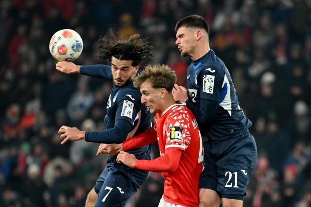 21 November 2025, Rhineland-Palatinate, Mainz: Hoffenheim's Leon Avdullahu and Albian Hajdari battle for a header with Mainz' Nelson Weiper battle for the ball during the German Bundesliga FSV Mainz 05 and TSG 1899 Hoffenheim at the Mewa Arena. Photo: Torsten Silz/dpa