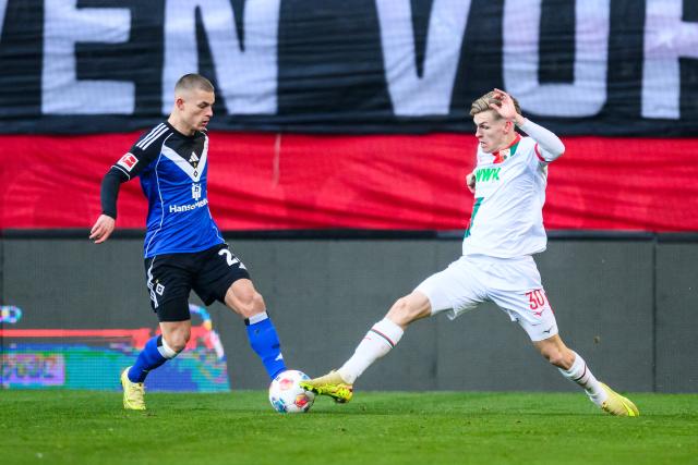 22 November 2025, Bavaria, Augsburg: Hamburger's Miro Muheim in action against Augsburg's Anton Kade during the German Bundesliga soccer match between FC Augsburg and Hamburger SV at the WWK-Arena. Photo: Tom Weller/dpa - IMPORTANT NOTICE: DFL and DFB regulations prohibit any use of photographs as image sequences and/or quasi-video.