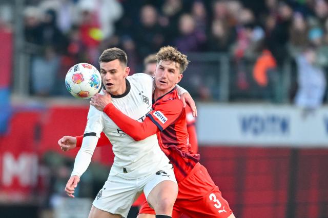 22 November 2025, Baden-Württemberg, Heidenheim: Moenchengladbach's Yannik Engelhardt (L) in action against Heidenheim's Jan Schoeppner during the G
erman Bundesliga soccer match between FC Heidenheim and Borussia Moenchengladbach at the Voith-Arena. Photo: Harry Langer/dpa - IMPORTANT NOTICE: DFL and DFB regulations prohibit any use of photographs as image sequences and/or quasi-video.
