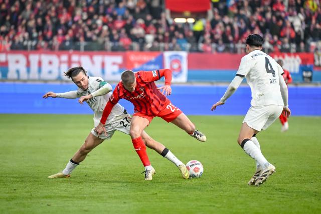 22 November 2025, Baden-Württemberg, Heidenheim: Moenchengladbach's Rocco Reitz and Kevin Diks in action against Heidenheim's Adrian Beck during the German Bundesliga soccer match between FC Heidenheim and Borussia Moenchengladbach at the Voith-Arena. Photo: Harry Langer/dpa - IMPORTANT NOTICE: DFL and DFB regulations prohibit any use of photographs as image sequences and/or quasi-video.