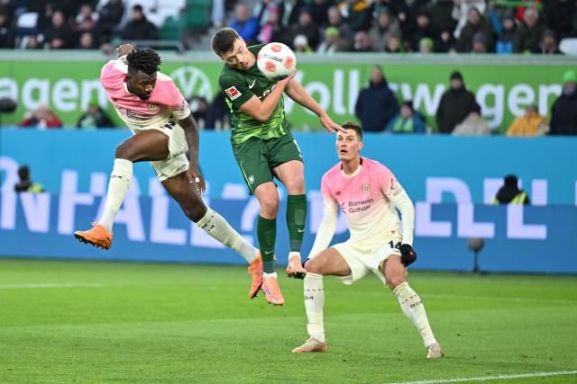 22 November 2025, Wolfsburg: Bayer Leverkusen's Edmond Tapsoba (L) heads to score his side's second goal during the German Bundesliga soccer match between VfL Wolfsburg and Bayer Leverkusen at the Volkswagen Arena. Photo: Swen Pförtner/dpa - IMPORTANT NOTICE: DFL and DFB regulations prohibit any use of photographs as image sequences and/or quasi-video.